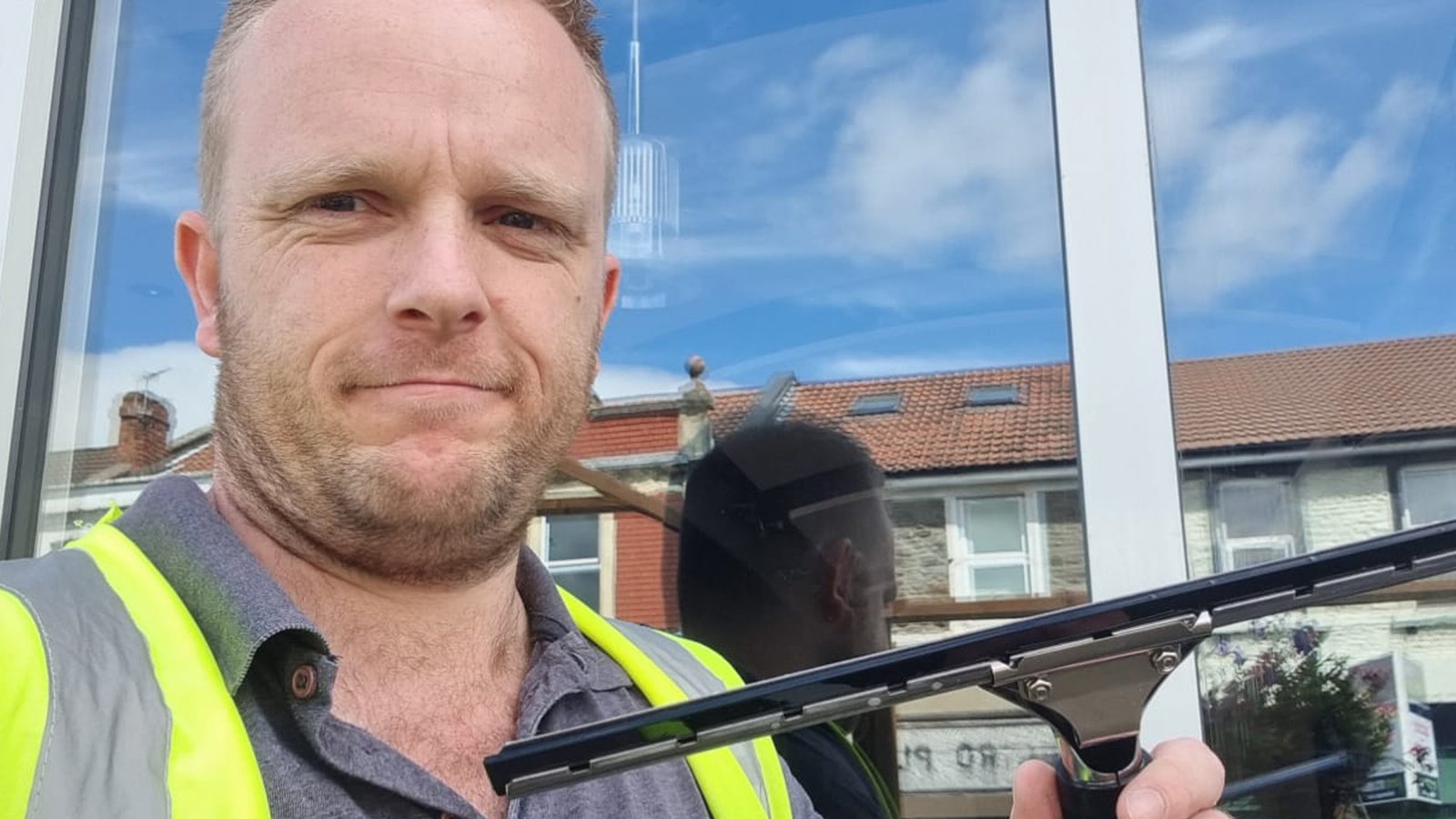 About Us 1 An image of a window cleaner holding a squeegee