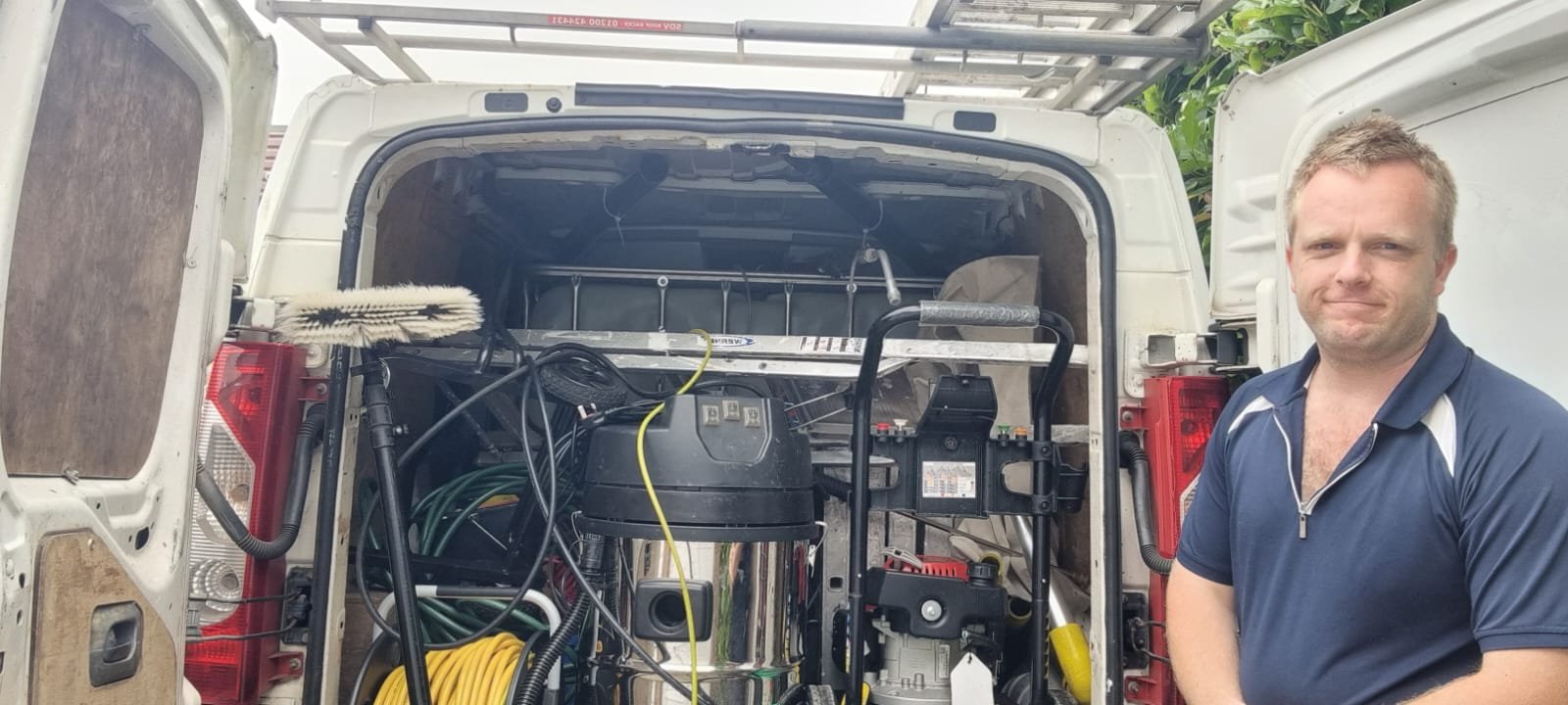 About Us 3 An image of a guy and the back of his van containing window and gutter equipments.