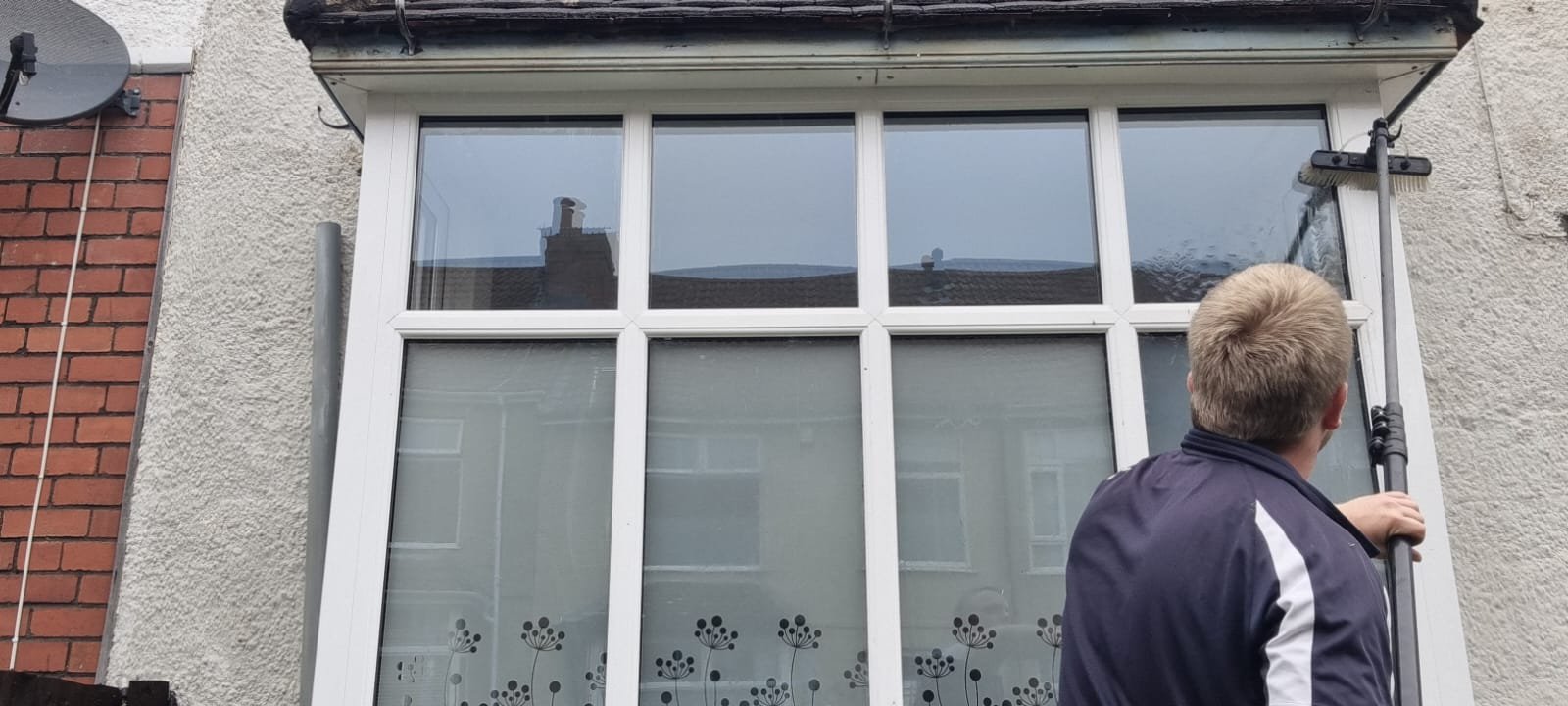 About Us 2 An image of a window cleaner using a water-fed pole