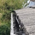 An image of a gutter full of debris and soil clogging the downpipes in a residential house in Bristol